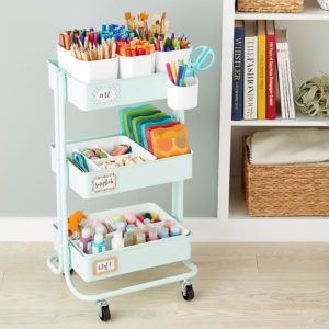 image of an art cart that has brushes, pens pencils and other art supplies inside.