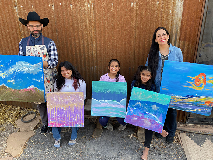 family holding paintings they created together