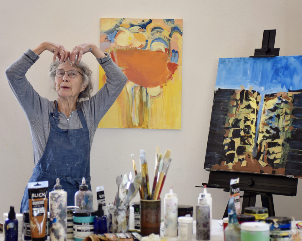 artist who is expressing her art style through her body movements that are similar to the painting she just created