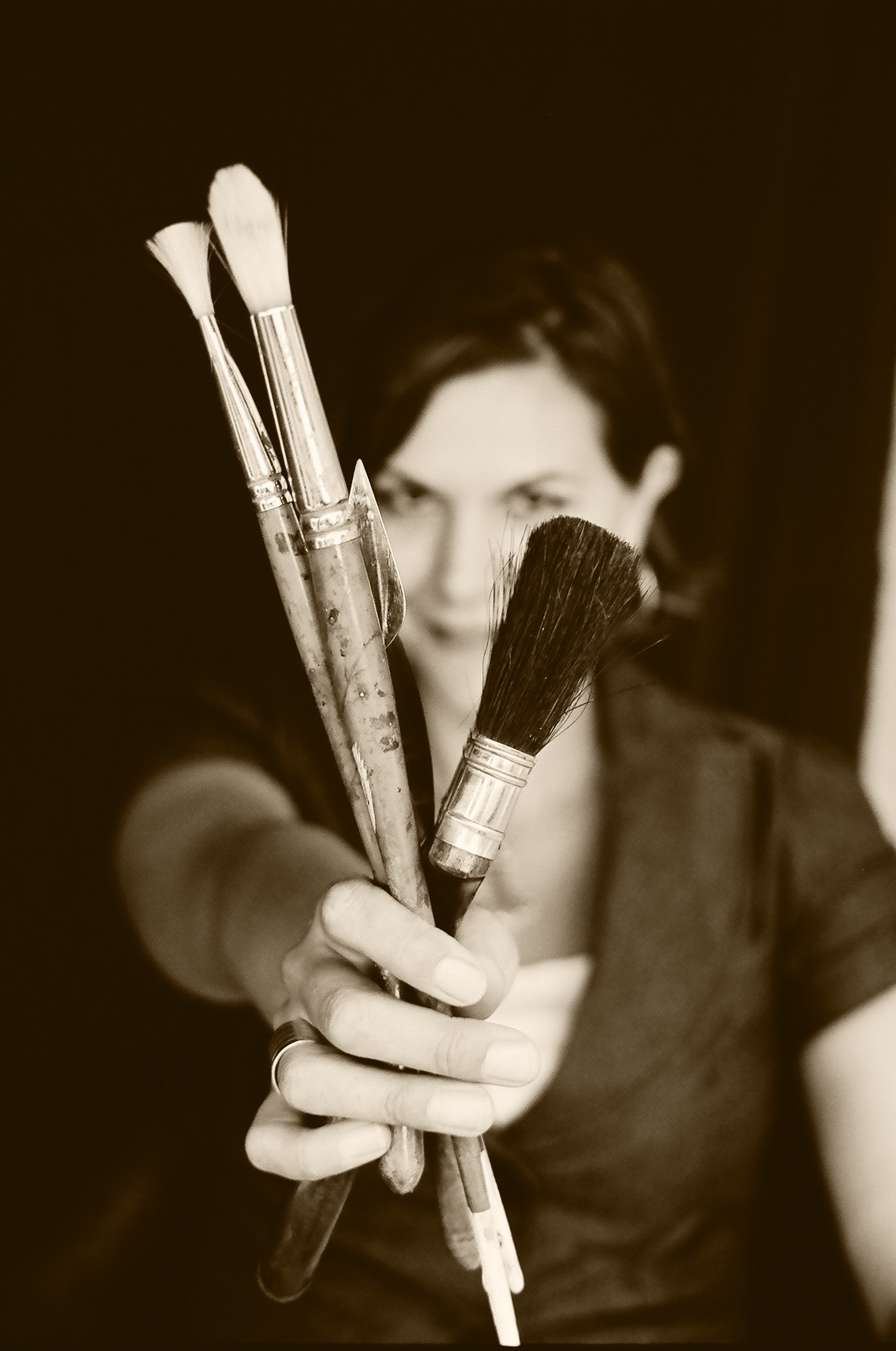 Andrea Cermanski holding painting brushes